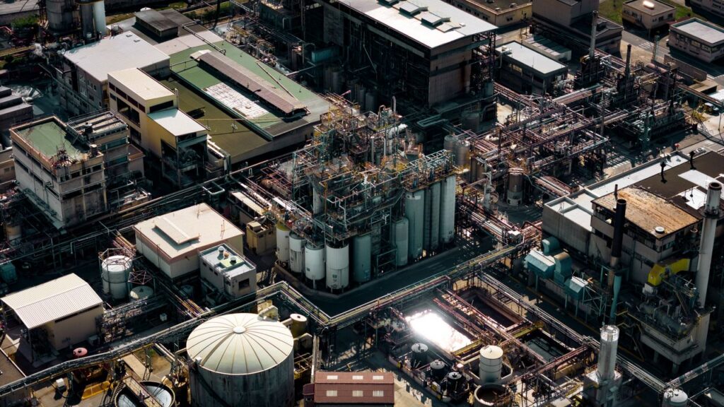 Aerial shot of a bustling industrial area in Marseille, France, showcasing silos and pipes.